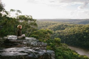 Beccy Howe author, meditating in nature, on mountain top