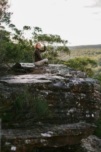Beccy How, author, waving hello on mountain top