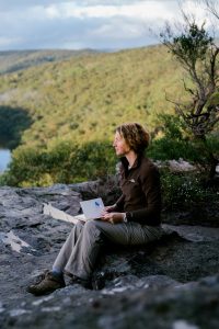 Beccy Howe author, writing on mountain top