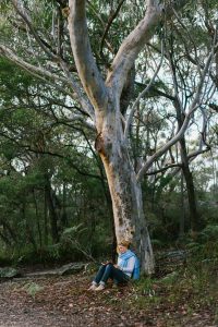 Beccy Howe Author writing under a tree
