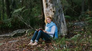 Beccy Howe author, writing under a tree close-up